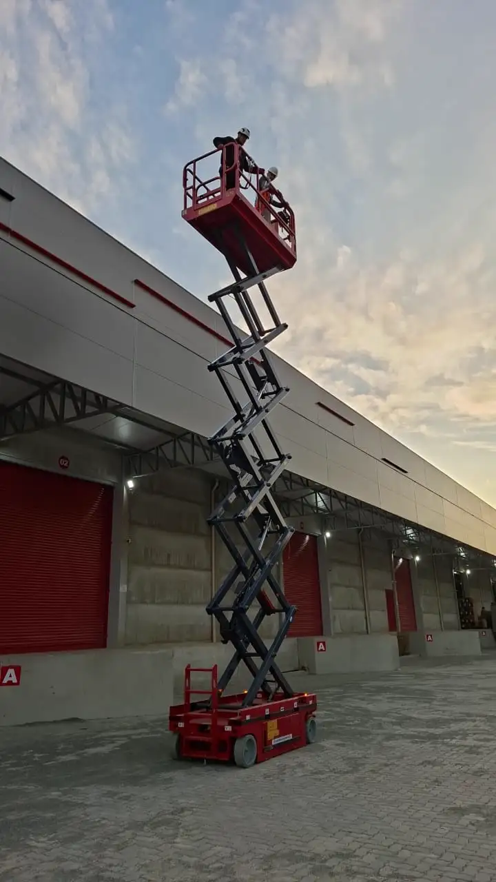 Participantes em capacitação prática com plataforma elevatória tesoura.